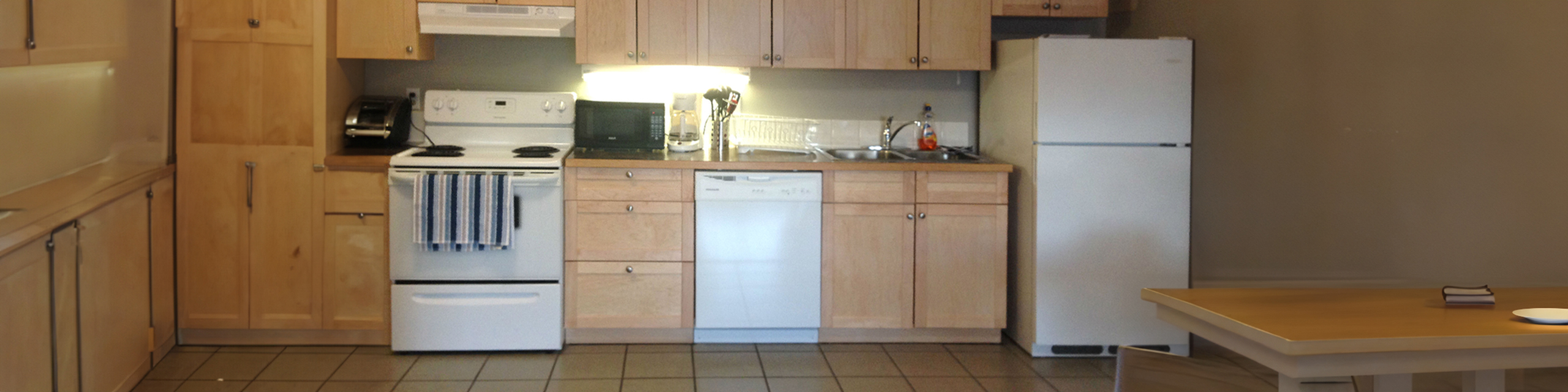Inviting kitchen with warm wooden cabinetry, modern appliances, and a cozy dining area perfect for culinary creativity.