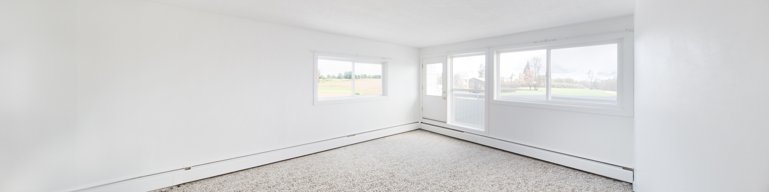 Bright and spacious room with panoramic windows, offering serene countryside views and abundant natural light.
