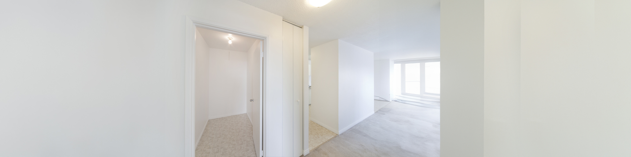 Bright and airy apartment hallway with modern finishes and ample natural light streaming through large windows.