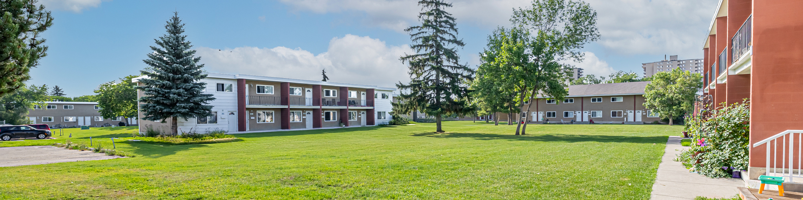 Charming apartment complex nestled in lush greenery with spacious lawns and vibrant community gardens.