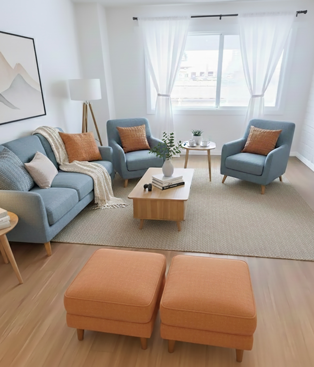 Bright and airy living room featuring modern furniture, a cozy gray sofa with orange accents, elegant armchairs, and a stylish coffee table, perfect for relaxation and entertaining.