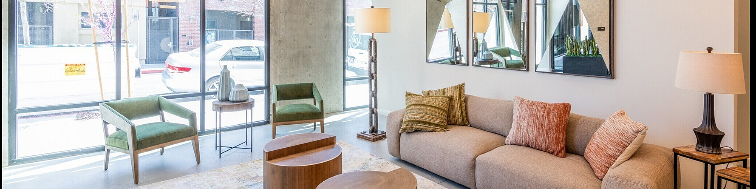 Bright and spacious room with modern neutral tones, featuring a cozy corner and ample natural light.