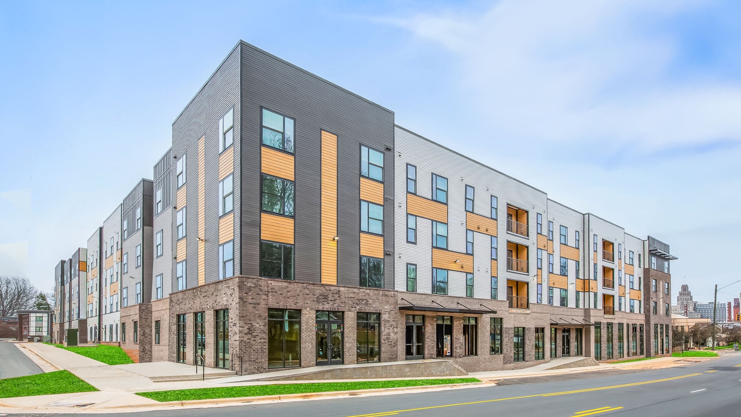 Modern apartment complex with contemporary architecture, large windows, and inviting street presence.