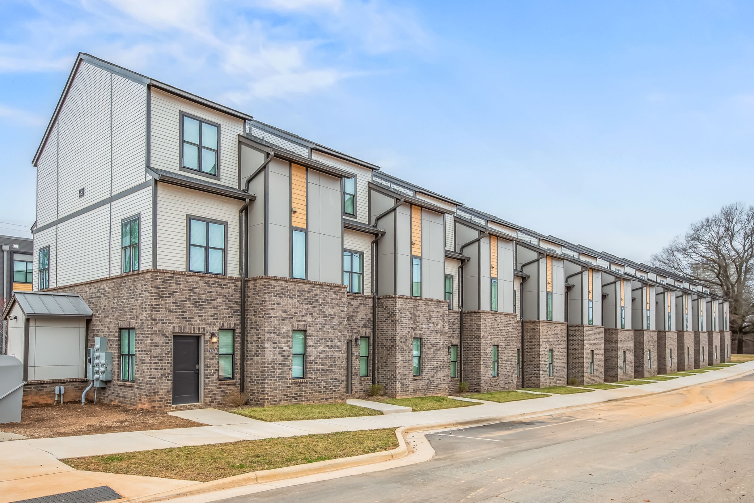 Modern townhouse exterior with stunning brickwork and sleek design elements on a sunny day, perfect for contemporary living.