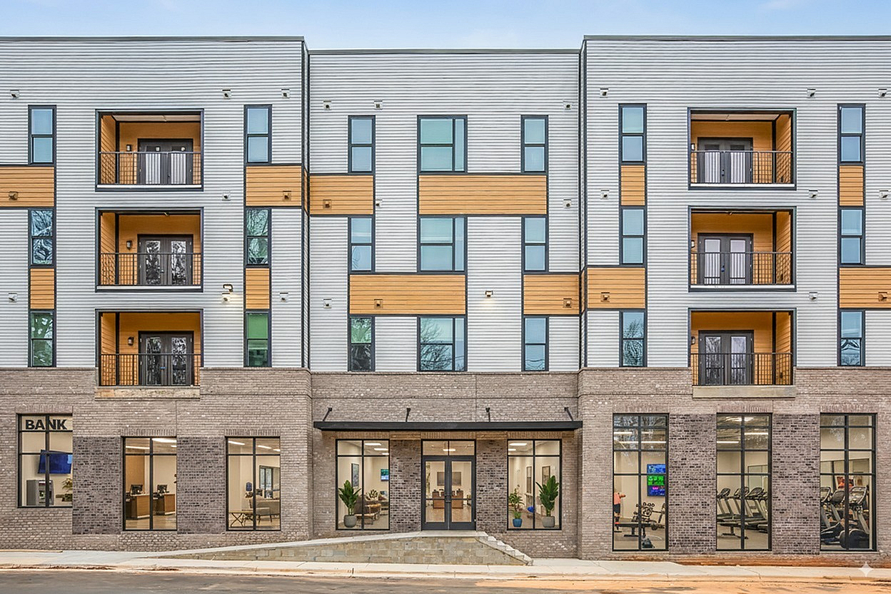 Modern apartment building with stylish balconies and large windows, featuring a gym and a welcoming entrance.