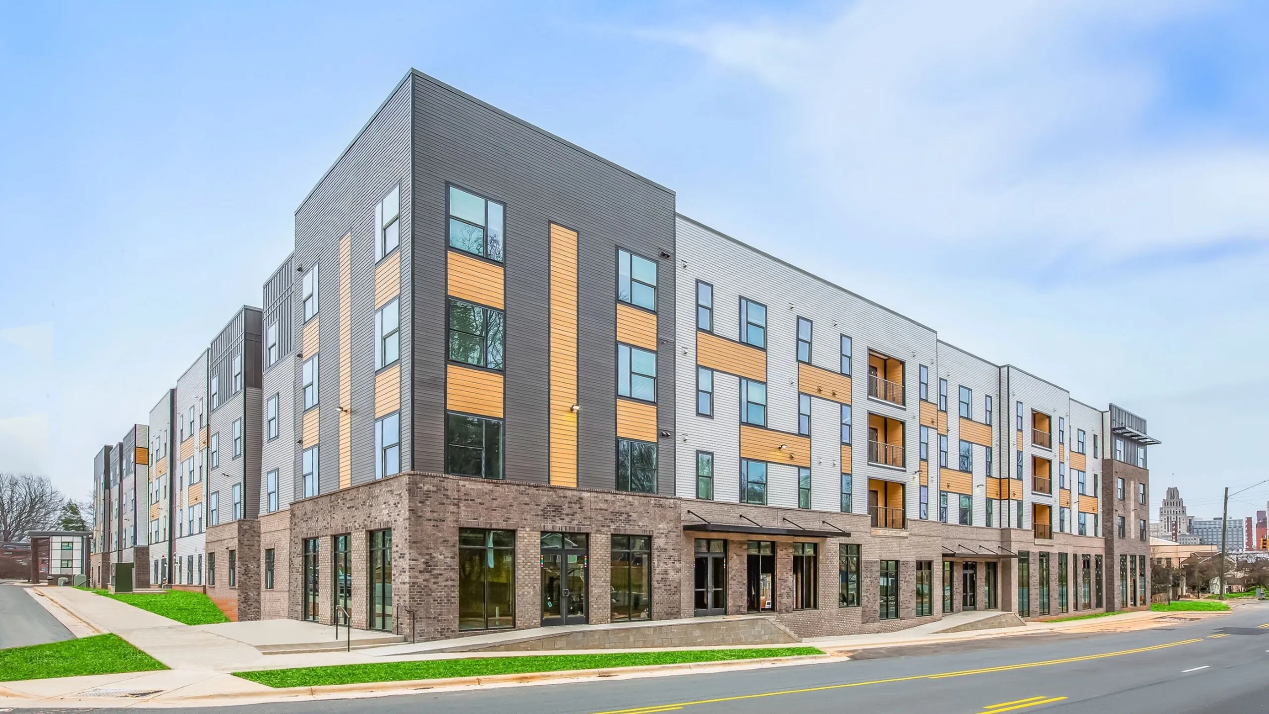 Modern apartment complex with stylish architecture, featuring multi-story design and large windows for natural light.