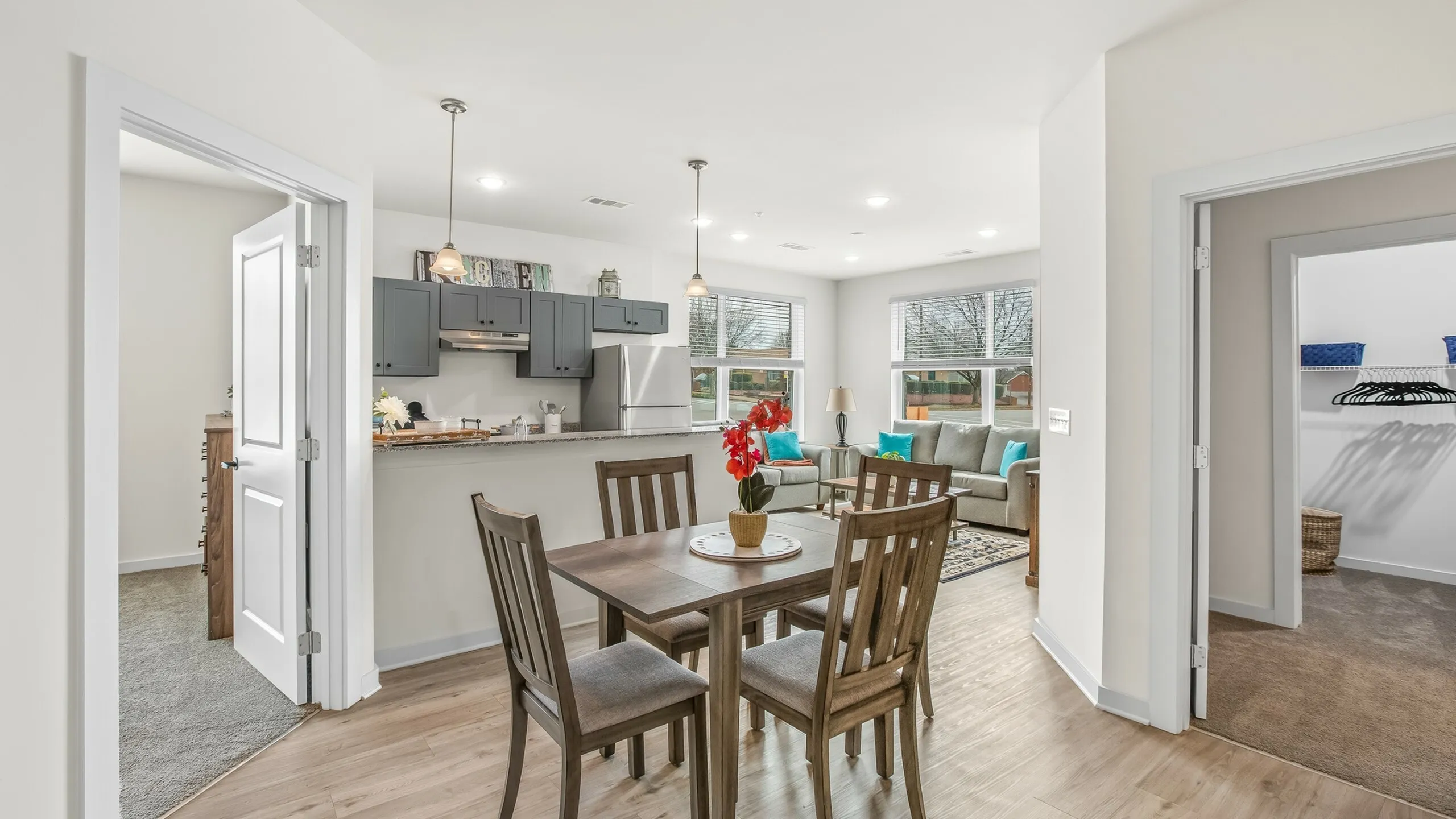 Charming open-concept living space featuring a modern kitchen, cozy dining area, and inviting living room with large windows.