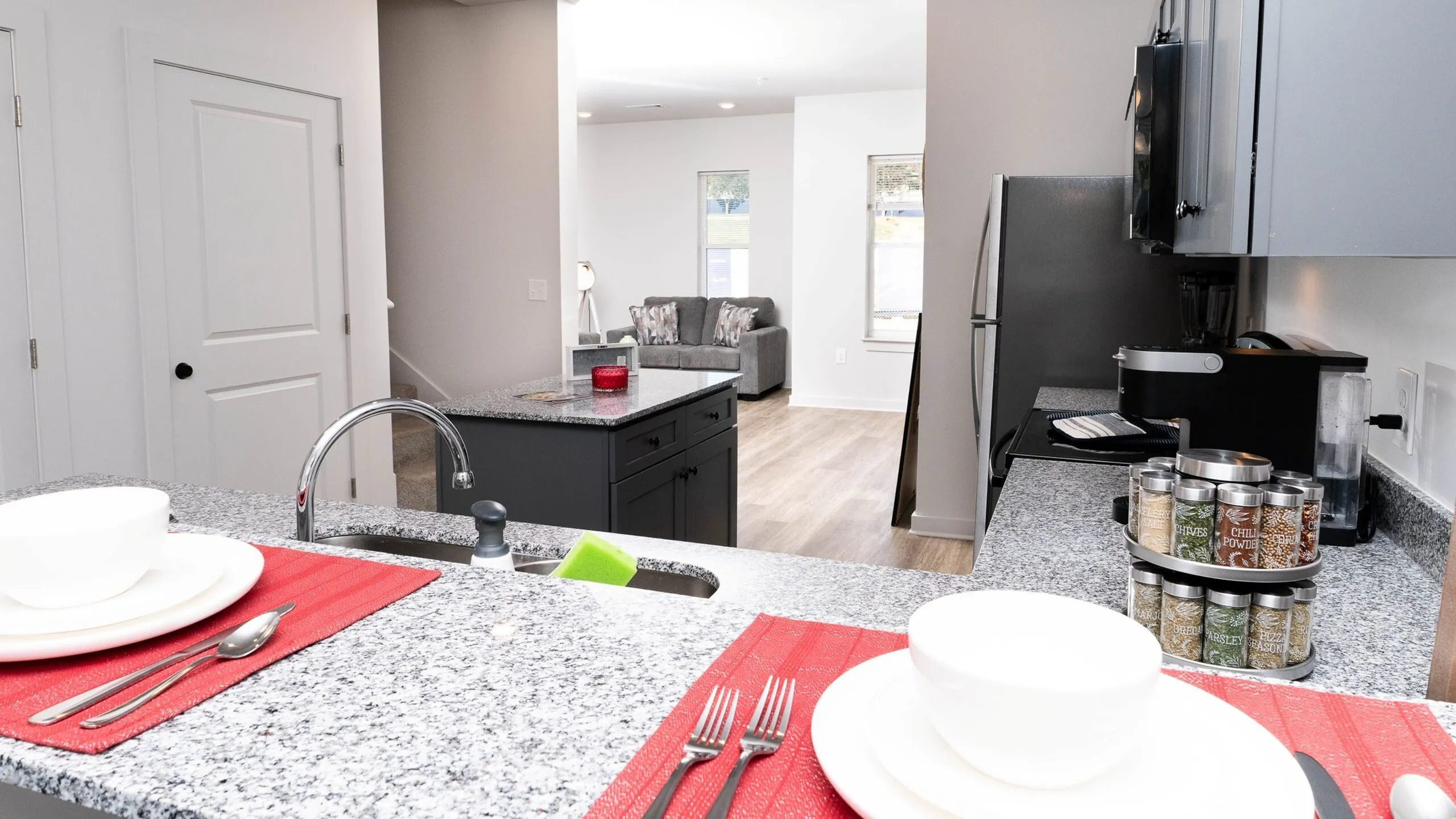 Chic modern kitchen with granite countertops, open layout, and a cozy living space in a bright apartment.