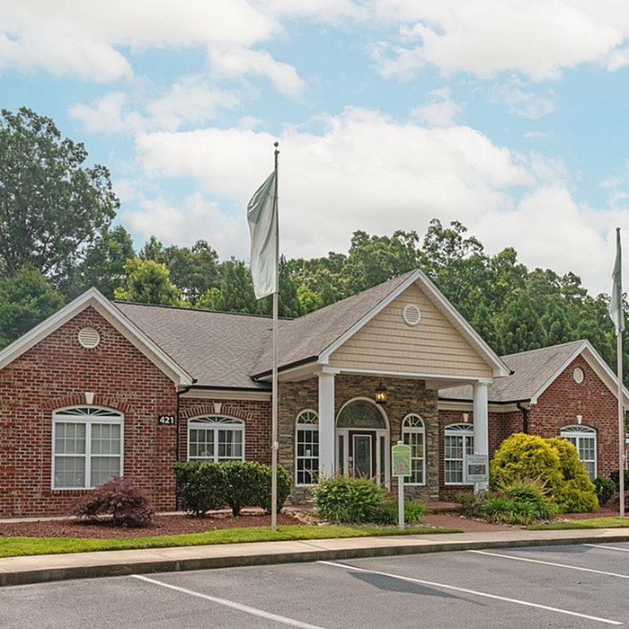 Charming brick community center with lush greenery and a welcoming entrance.