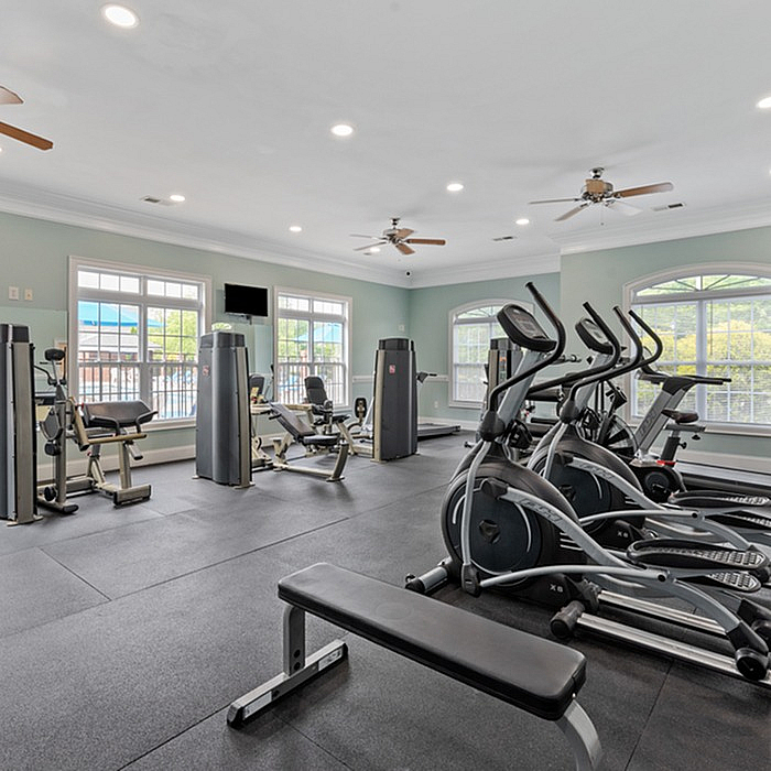 Bright and modern fitness center with cardio machines, weight equipment, and large windows.