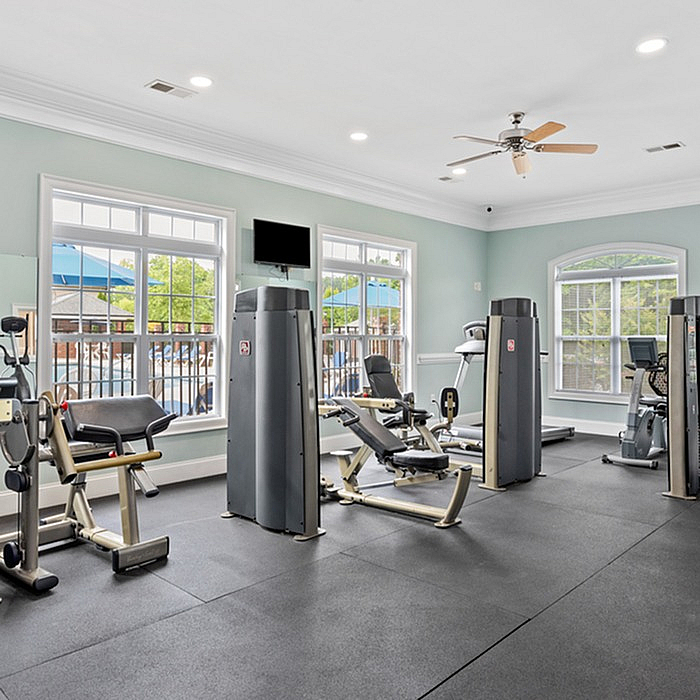Bright fitness center with modern exercise equipment and large windows for natural light.
