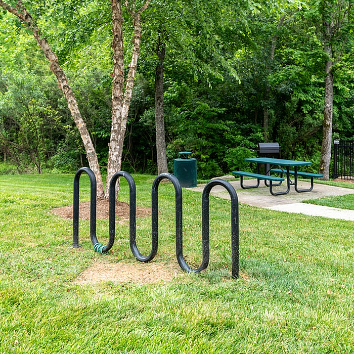 Inviting outdoor space with bike rack, picnic table, and lush green surroundings.