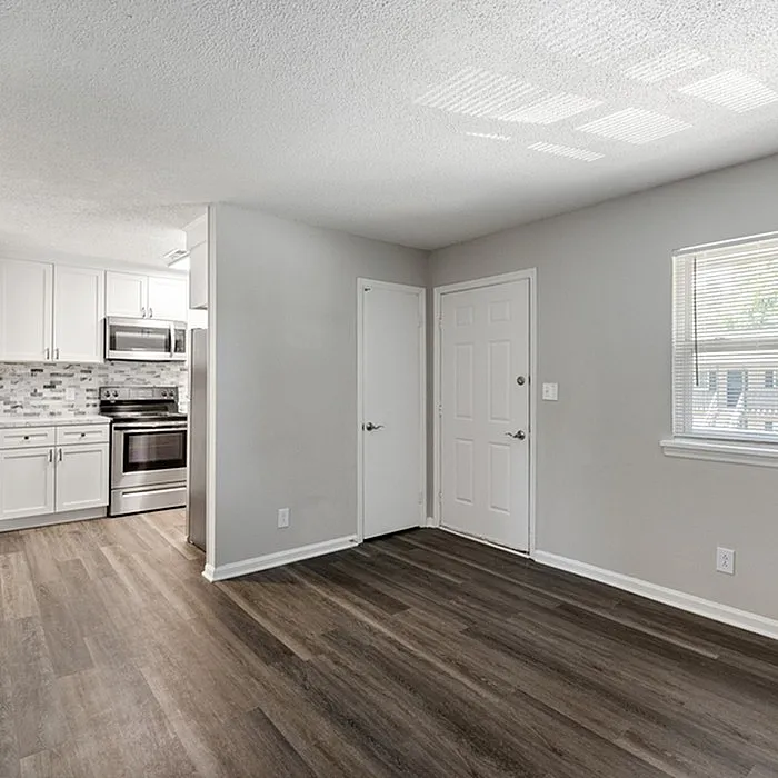 Modern open-concept kitchen area with elegant white cabinetry and stainless steel appliances.