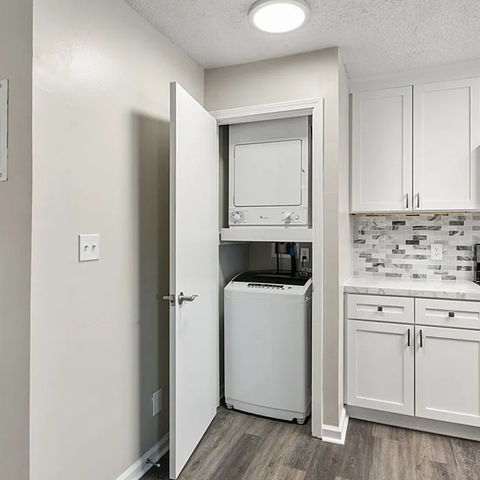 Efficient kitchen space with stackable washer and dryer in a modern utility nook.