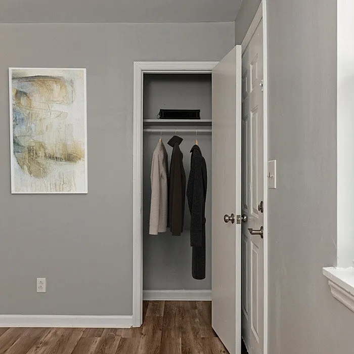 Contemporary closet space with sleek clothing storage and elegant wall art.