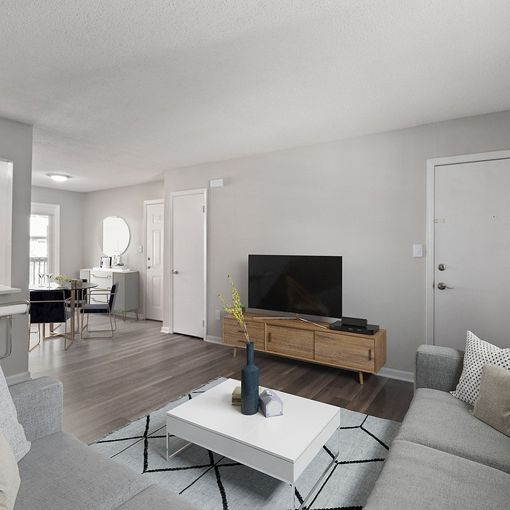 Modern living room with sleek decor, featuring a cozy sofa, stylish coffee table, and a large TV on a wooden stand.