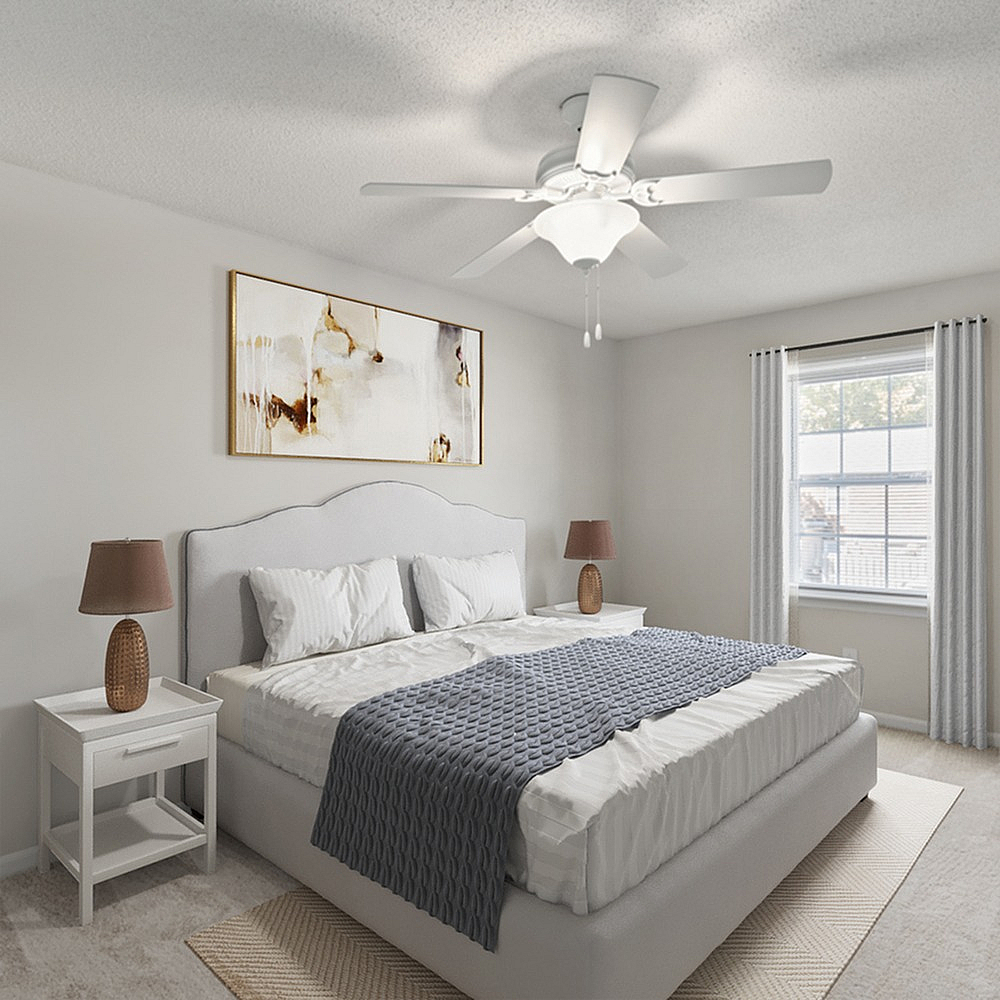 Inviting bedroom with a plush bed, modern ceiling fan, and tasteful decor.