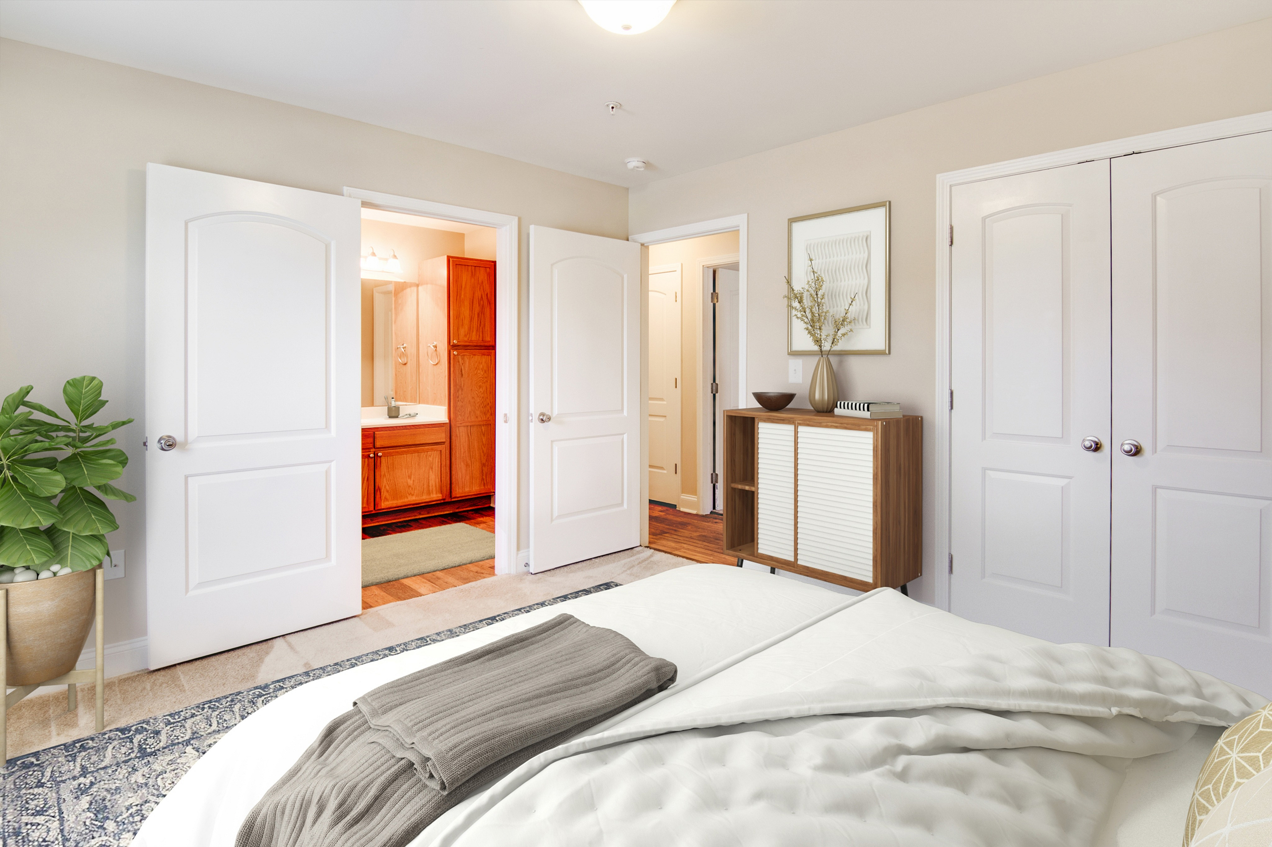 Spacious bedroom with elegant decor, opening into a modern bathroom.