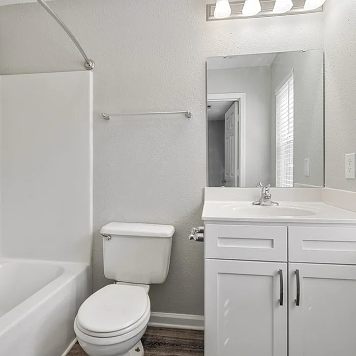Modern bathroom with sleek white fixtures, elegant vanity, and bright lighting, offering a fresh and inviting atmosphere.