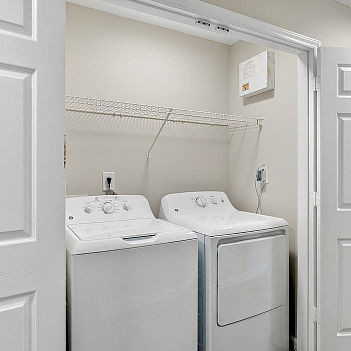 Modern laundry area featuring a sleek washer and dryer set within an accessible closet.