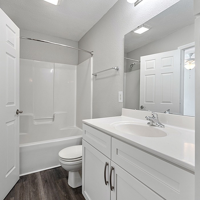 Modern bathroom with sleek white fixtures, elegant vanity, and bright lighting, offering a fresh and inviting atmosphere.