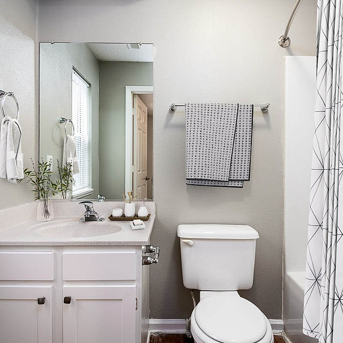 Modern bathroom with elegant fixtures, a spacious countertop, and a stylish shower curtain for a fresh and inviting look.