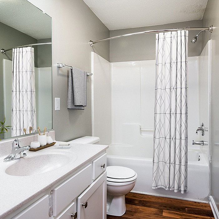 Bright and modern bathroom featuring a sleek vanity, elegant mirror, and contemporary shower curtain.