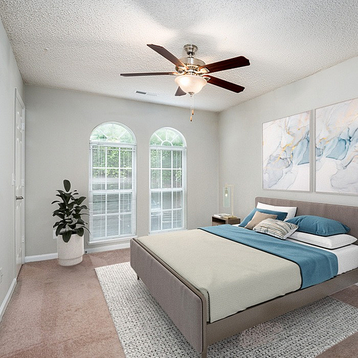 Inviting bedroom with a plush bed, modern decor, and sunlit arched windows, creating a cozy retreat.