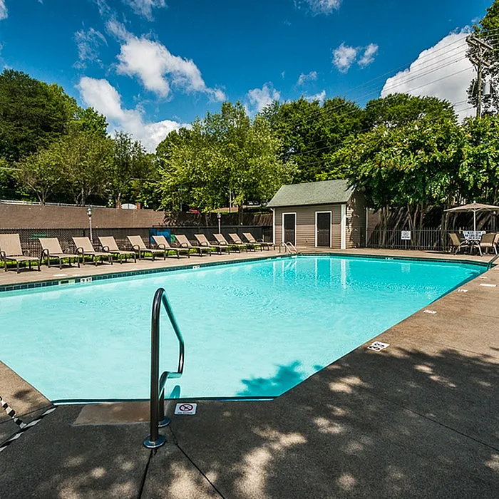 Inviting outdoor swimming pool area with surrounding sun loungers and lush greenery, perfect for relaxation and leisure.