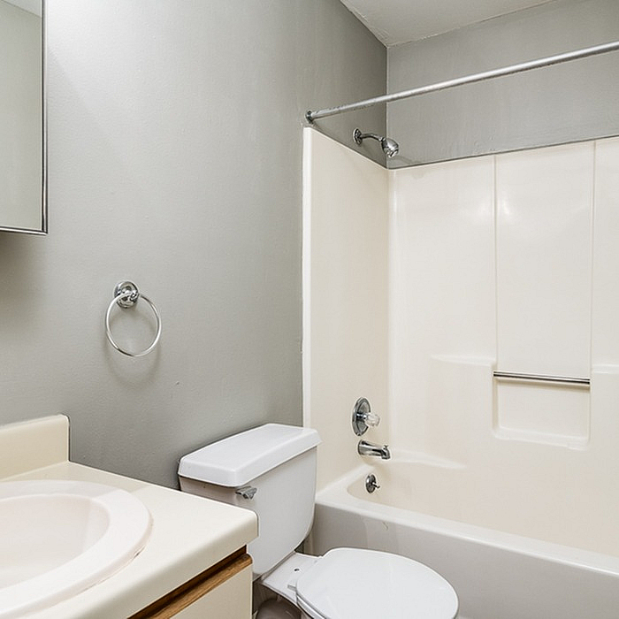 Sleek and modern bathroom featuring a pristine bathtub, elegant fixtures, and calming neutral tones.