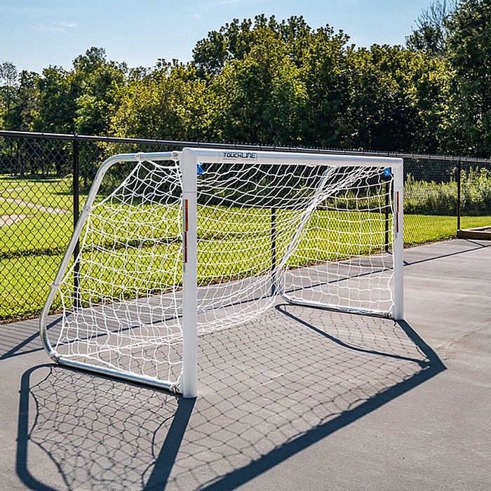 Outdoor sports area with a sturdy soccer goal set against a lush green backdrop, perfect for recreational activities.