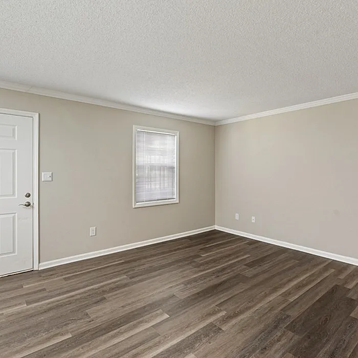 Bright and inviting empty room featuring elegant hardwood flooring and soft beige walls, perfect for customization and decor inspiration.