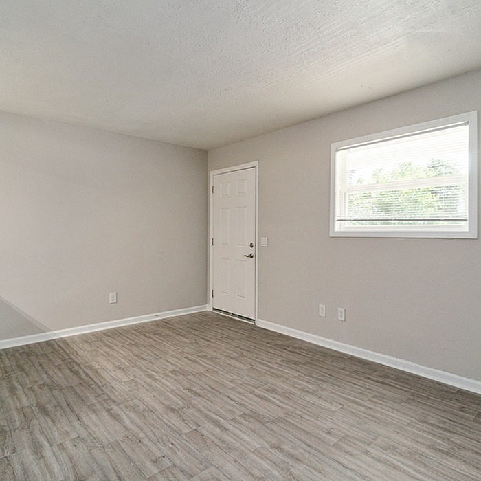 Bright and spacious room with modern wood flooring and abundant natural light, perfect for a cozy and stylish living space.
