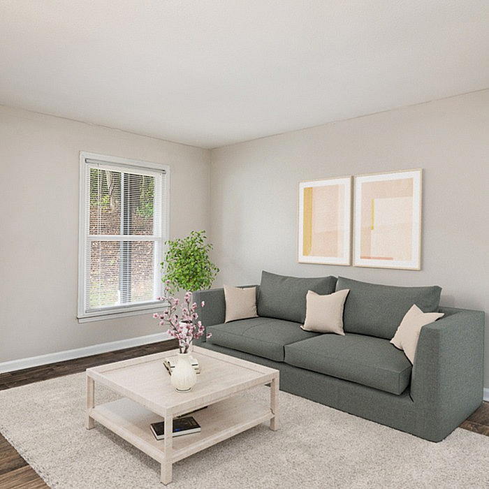 Inviting living room with elegant gray sofa, chic coffee table, and natural light streaming through modern window.