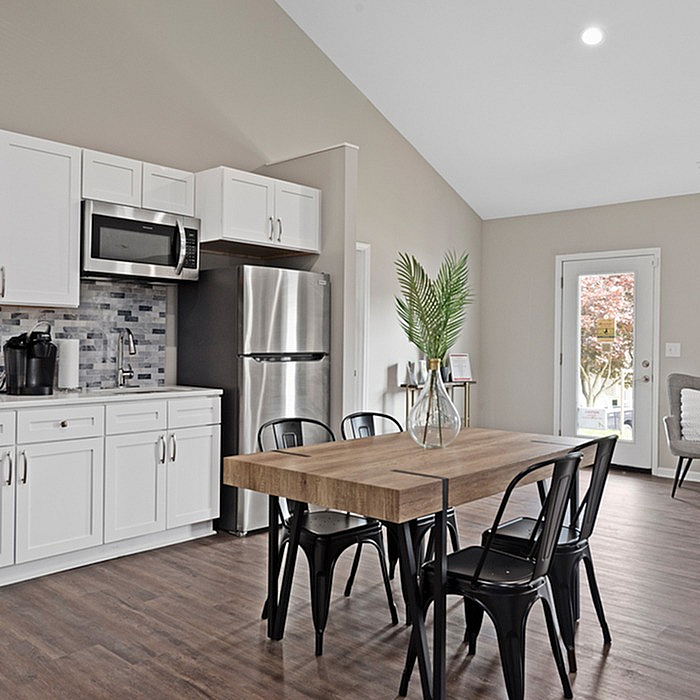 Contemporary kitchen with stainless steel appliances, sleek cabinetry, and a chic dining area with modern decor, perfect for entertaining.