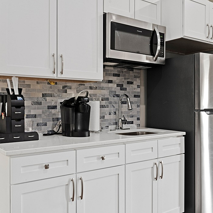Modern kitchen with sleek stainless steel appliances, elegant white cabinetry, and stylish tile backsplash.