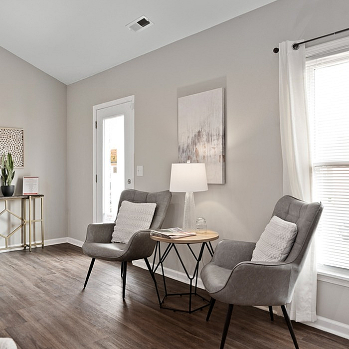 Chic and cozy living area with elegant chairs, stylish side table, and bright natural light.