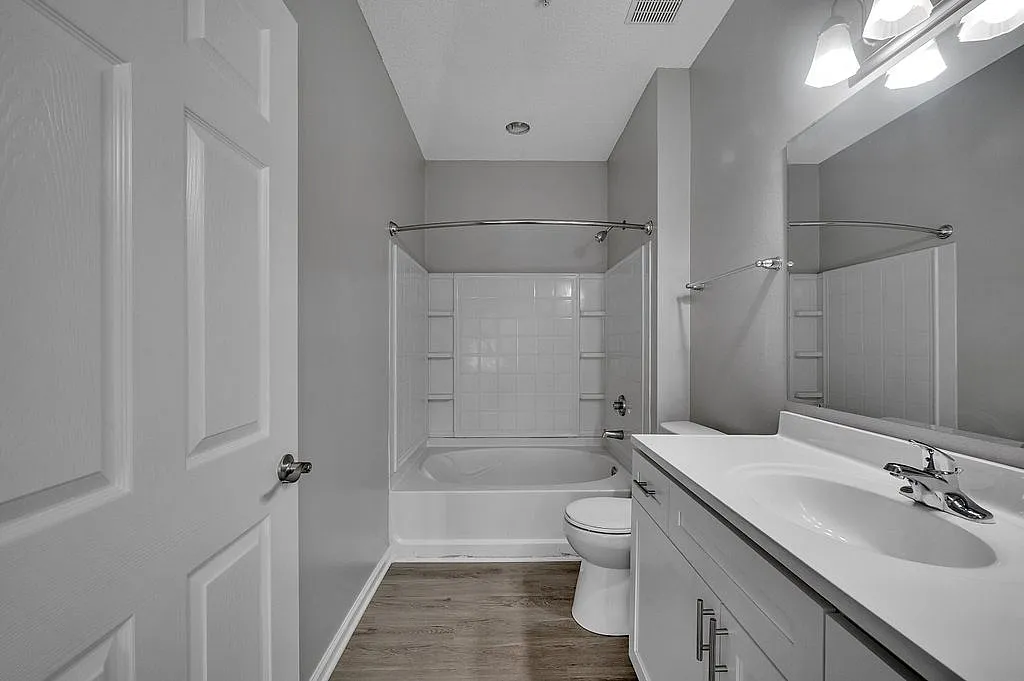 Modern and sleek bathroom featuring elegant white fixtures, ample storage, and stylish lighting.