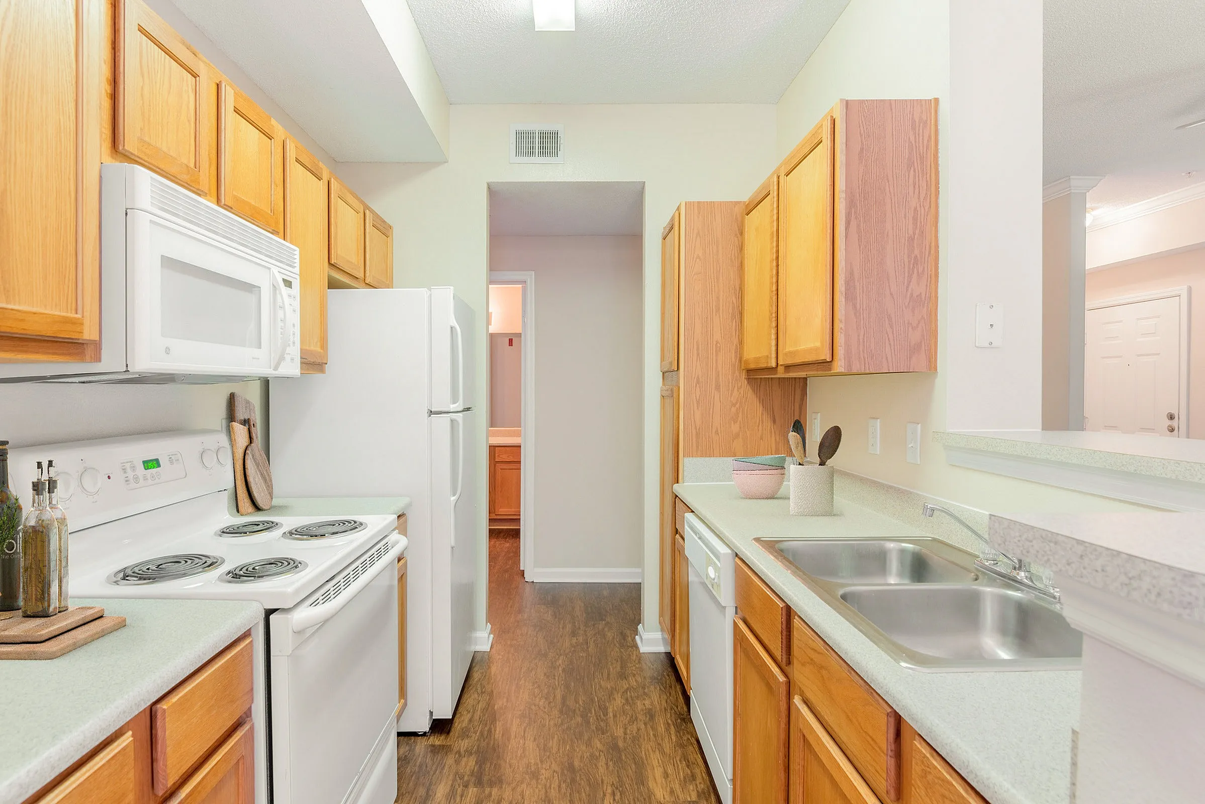 Bright and inviting galley kitchen with modern appliances, elegant wooden cabinetry, and sleek countertops.