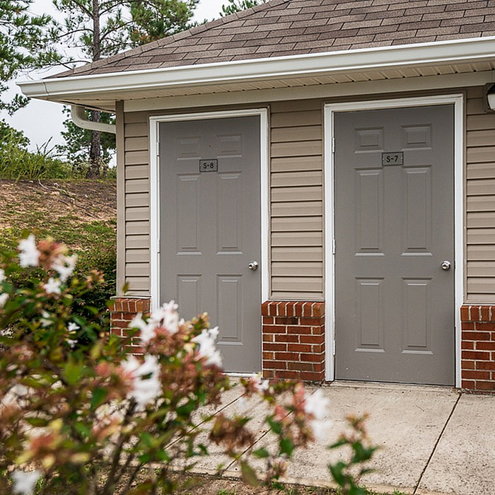 Charming exterior view with dual entrances, enhanced by vibrant greenery in the foreground.