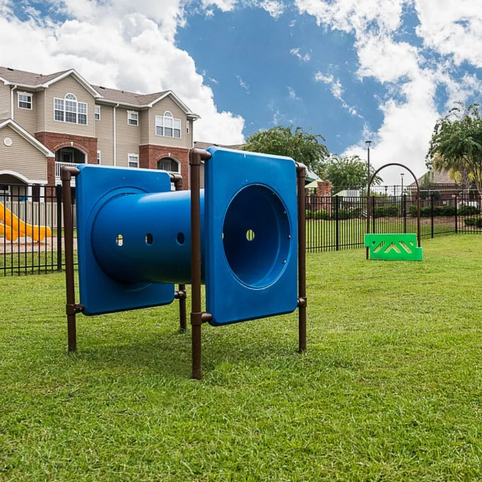 Charming apartment complex with a vibrant outdoor play area and clear blue skies, perfect for family-friendly living.