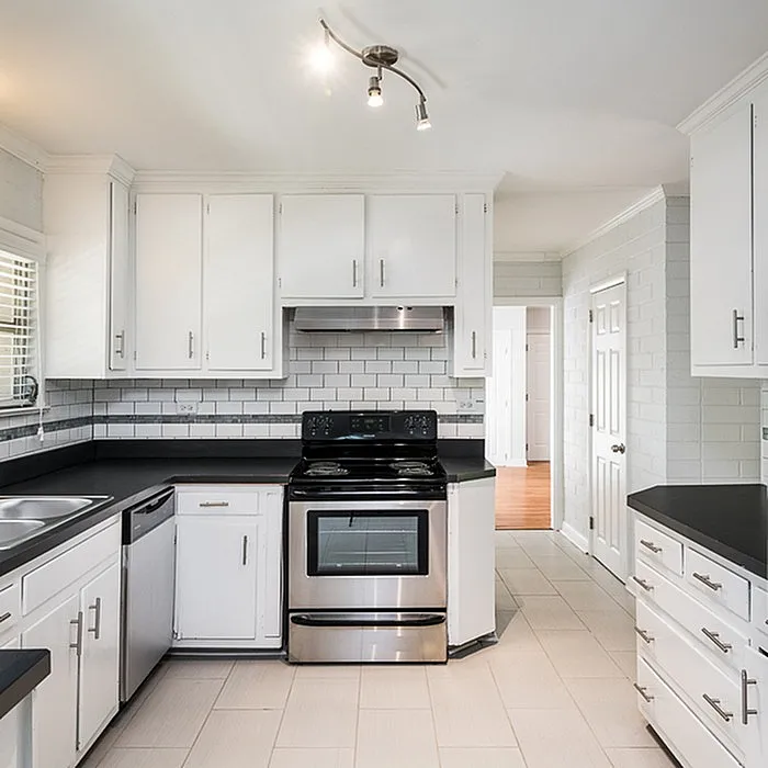 Modern kitchen with sleek white cabinetry, stainless steel appliances, and elegant subway tile backsplash, perfect for culinary creativity.