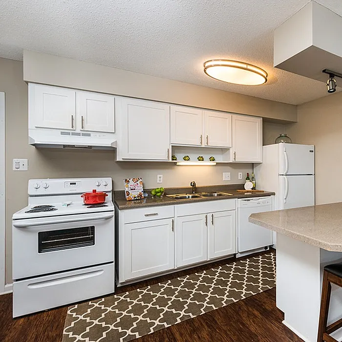 Modern kitchen with sleek white cabinetry, spacious countertops, and a cozy breakfast bar, perfect for culinary creativity.