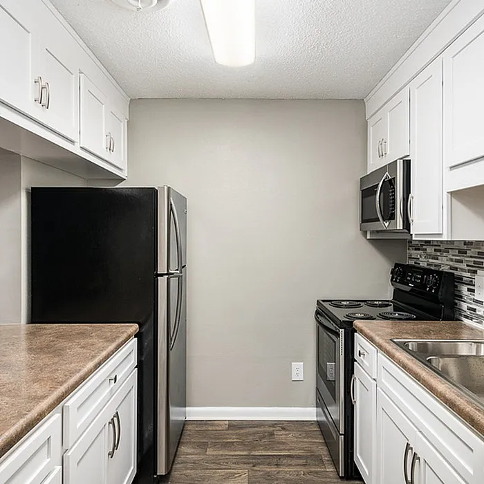 Modern kitchen with sleek black appliances, elegant cabinetry, and stylish backsplash, showcasing contemporary design and functionality.
