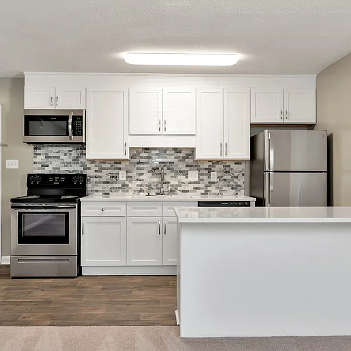 Modern kitchen with sleek stainless steel appliances, elegant white cabinetry, and stylish mosaic backsplash.