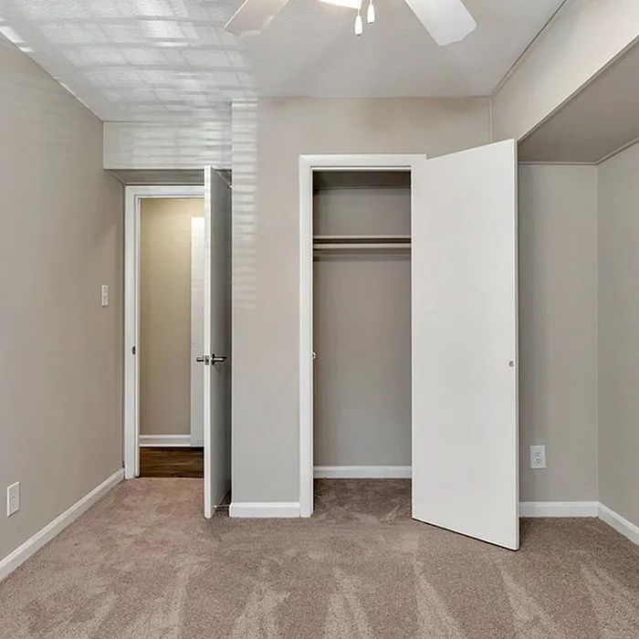 Bright, freshly painted room with plush carpet and ample closet space, perfect for a cozy retreat.
