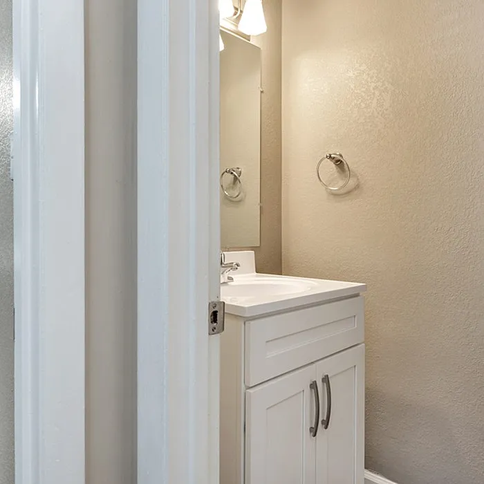 Elegant bathroom with modern white vanity, polished fittings, and ambient lighting.