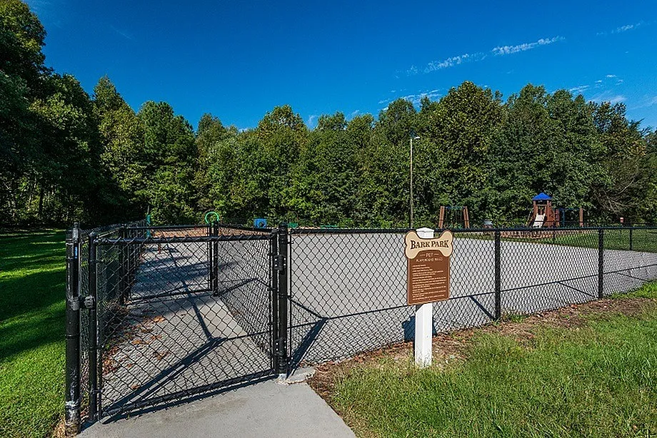 Inviting fenced dog park surrounded by lush greenery, perfect for outdoor fun and pet-friendly activities.