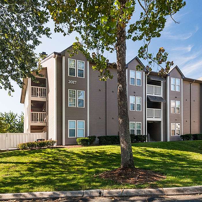 Attractive apartment building with modern architecture, lush greenery, and inviting balconies.