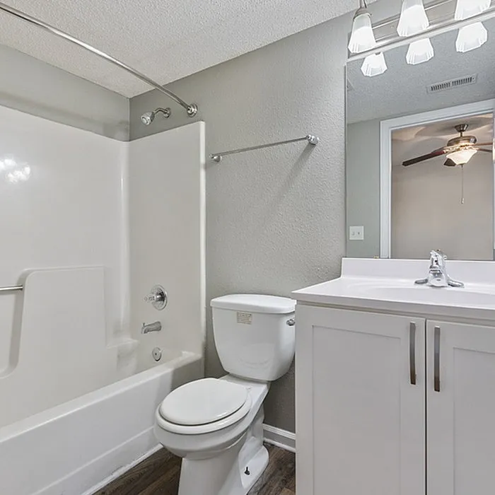 Elegant bathroom showcasing a modern white vanity, sleek bathtub, and stylish lighting fixtures.
